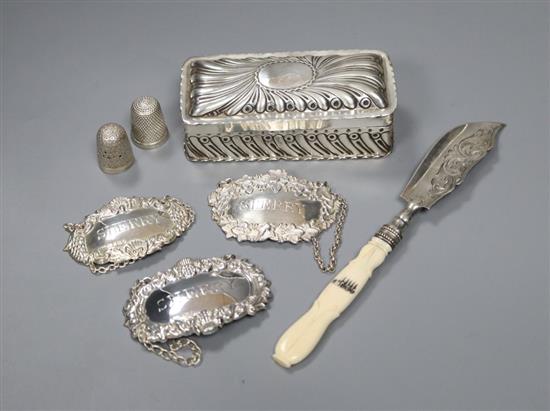 A Victorian silver trinket box, three silver wine labels, a Victorian silver butter knife & two silver thimbles.